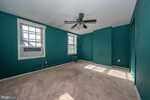 spare room with cooling unit, a baseboard radiator, carpet floors, and ceiling fan