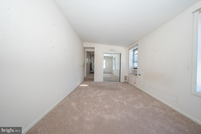 empty room with light colored carpet and cooling unit