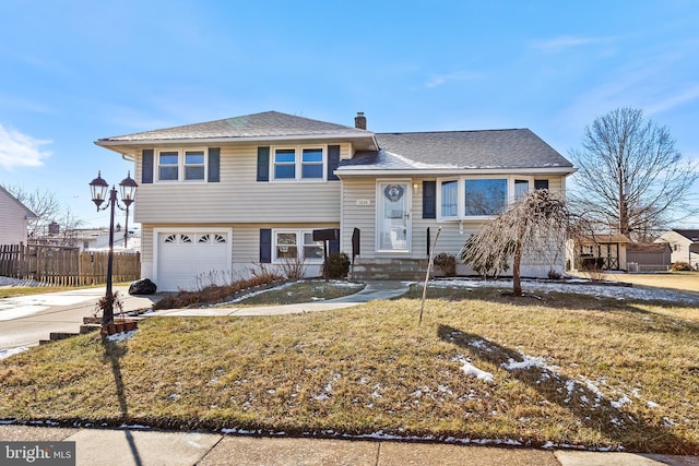 split level home featuring a garage and a front yard