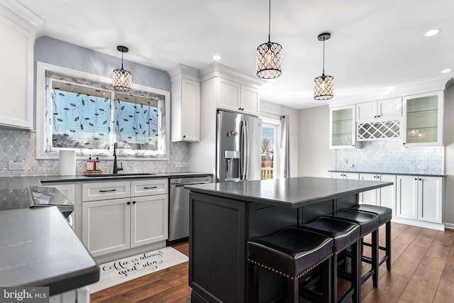 kitchen featuring a breakfast bar, appliances with stainless steel finishes, white cabinets, and a kitchen island