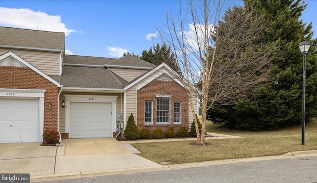 view of front of home with brick siding, roof with shingles, an attached garage, a front yard, and driveway