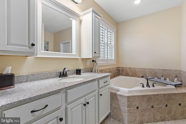 bathroom featuring vanity and a relaxing tiled tub