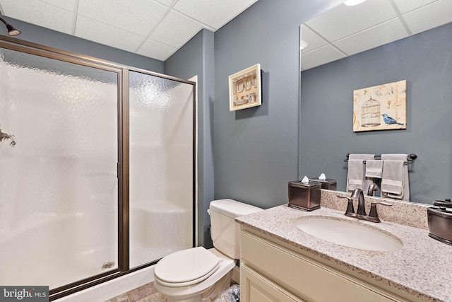 bathroom featuring a paneled ceiling, toilet, walk in shower, and vanity