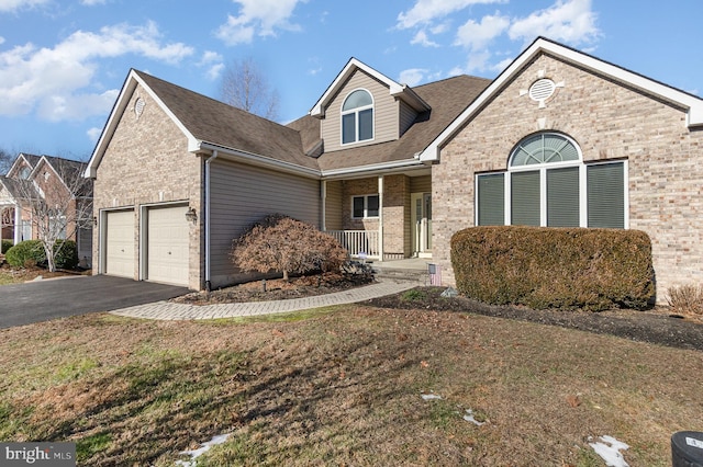 view of front of house with a porch, a front lawn, and a garage