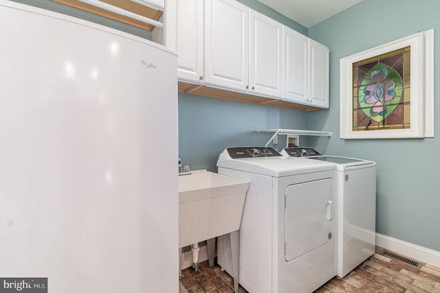 washroom featuring washer and dryer, light hardwood / wood-style flooring, cabinets, and sink