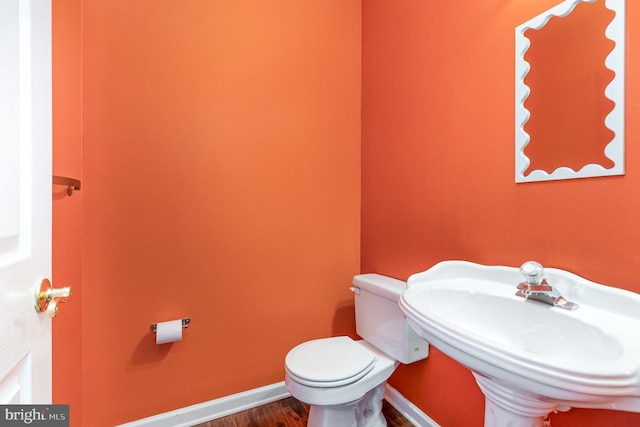 bathroom with sink, toilet, and hardwood / wood-style flooring