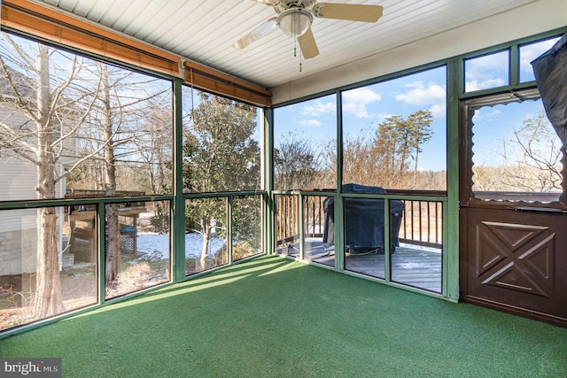 unfurnished sunroom with ceiling fan