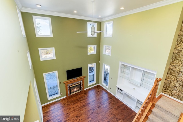 living room featuring dark wood-type flooring, crown molding, and plenty of natural light