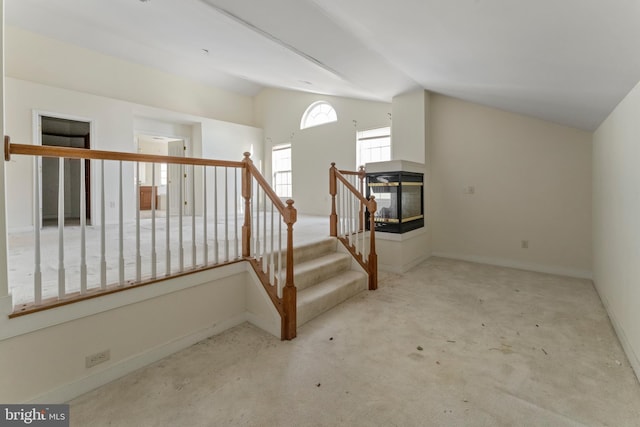 interior space featuring lofted ceiling and a multi sided fireplace