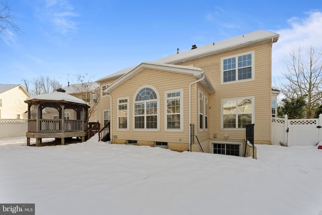 snow covered rear of property with a gazebo