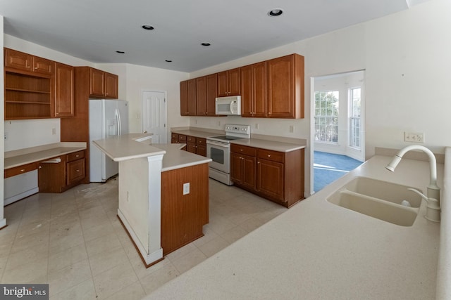 kitchen featuring sink, white appliances, and a kitchen island