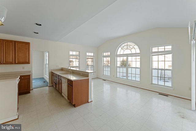 kitchen featuring vaulted ceiling, dishwasher, and sink