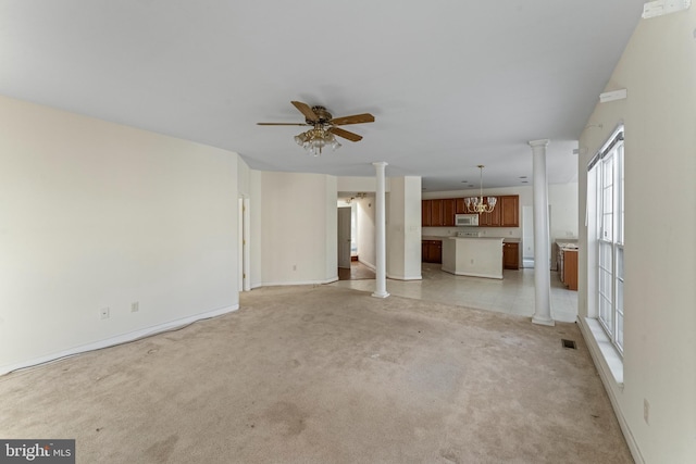 unfurnished living room featuring ceiling fan with notable chandelier and light carpet