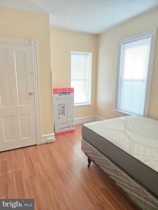 bedroom featuring a textured ceiling and light hardwood / wood-style floors