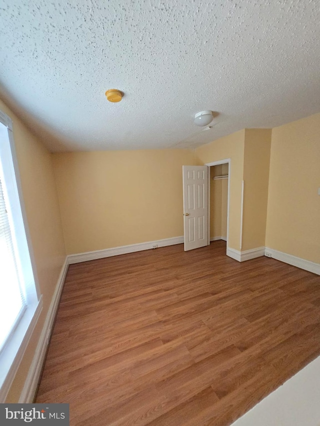 empty room with a textured ceiling and hardwood / wood-style floors