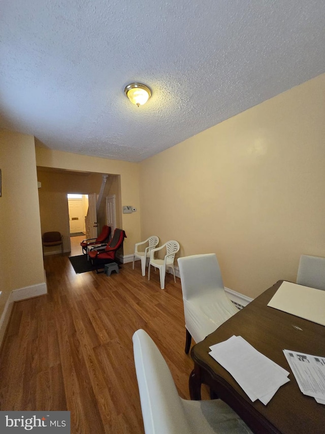 dining room featuring a textured ceiling and hardwood / wood-style floors