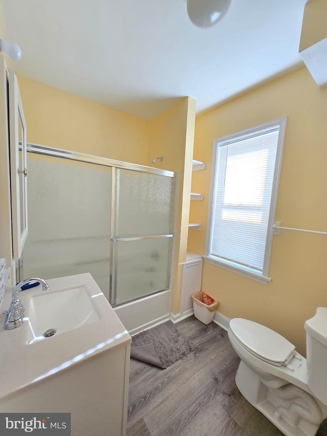 full bathroom with toilet, shower / bath combination with glass door, vanity, and hardwood / wood-style flooring