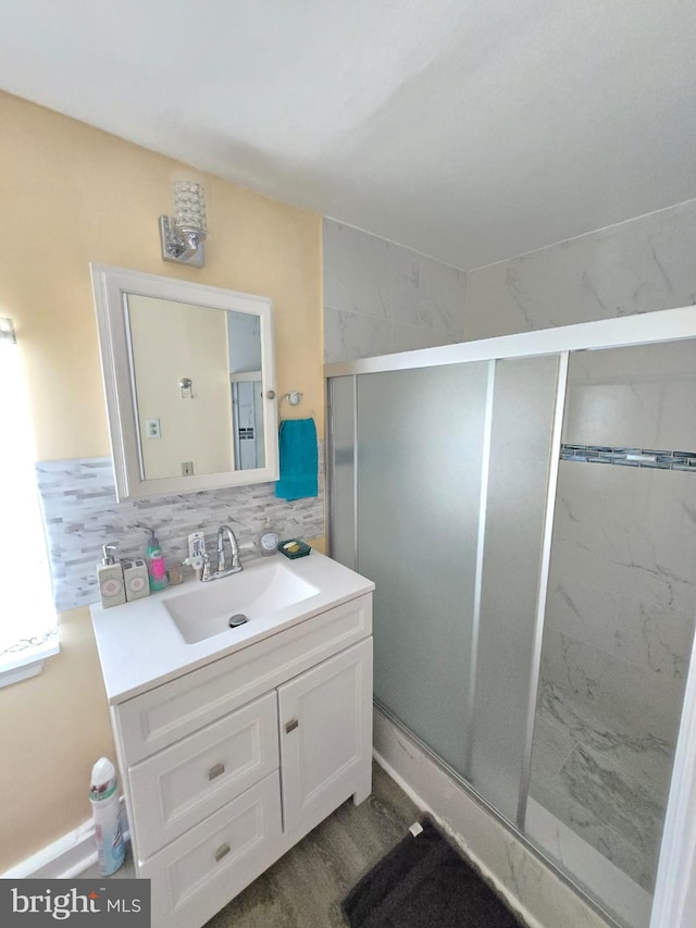 bathroom with vanity, walk in shower, decorative backsplash, and hardwood / wood-style flooring