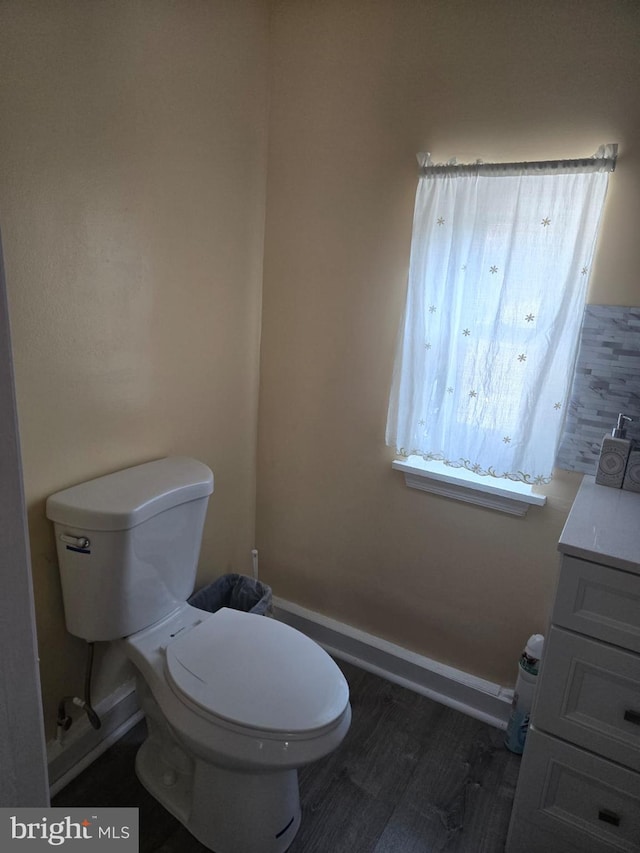 bathroom with toilet, hardwood / wood-style flooring, and vanity