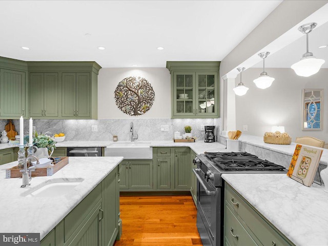 kitchen with stainless steel appliances, green cabinetry, and sink