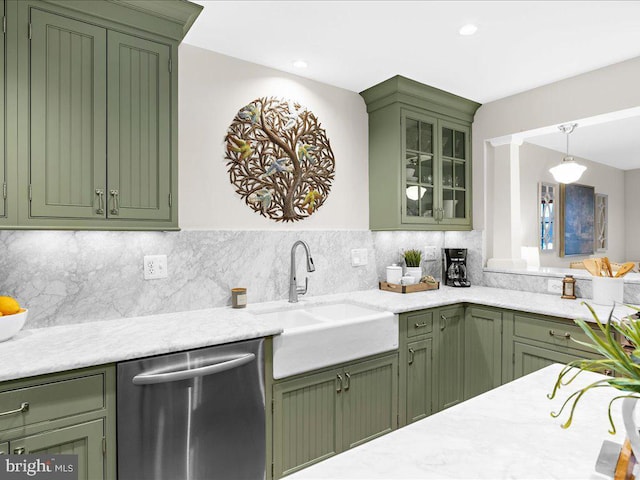 kitchen with sink, green cabinetry, stainless steel dishwasher, hanging light fixtures, and decorative backsplash