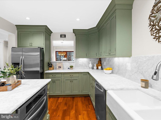 kitchen featuring appliances with stainless steel finishes, backsplash, sink, dark hardwood / wood-style floors, and green cabinetry