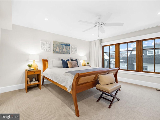 carpeted bedroom with ceiling fan and multiple windows