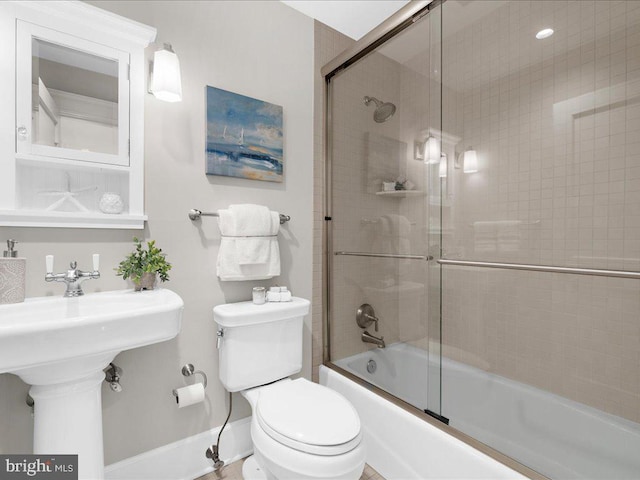 full bathroom with shower / bath combination with glass door, sink, and toilet