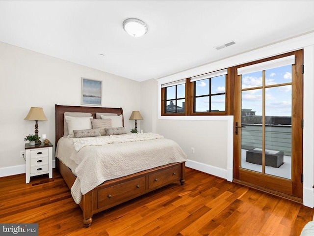 bedroom featuring access to exterior and dark hardwood / wood-style floors