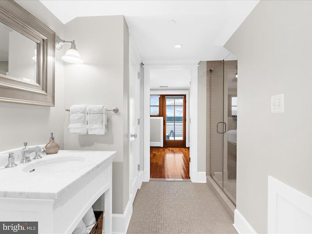 bathroom with sink and a shower with door