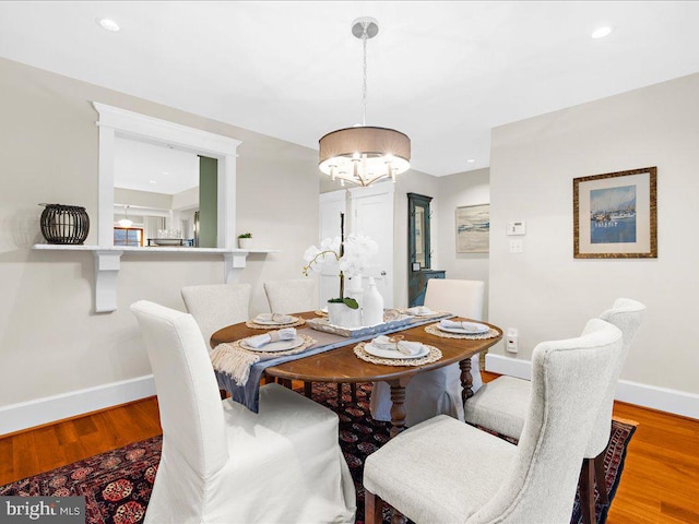 dining space with light wood-type flooring and a notable chandelier