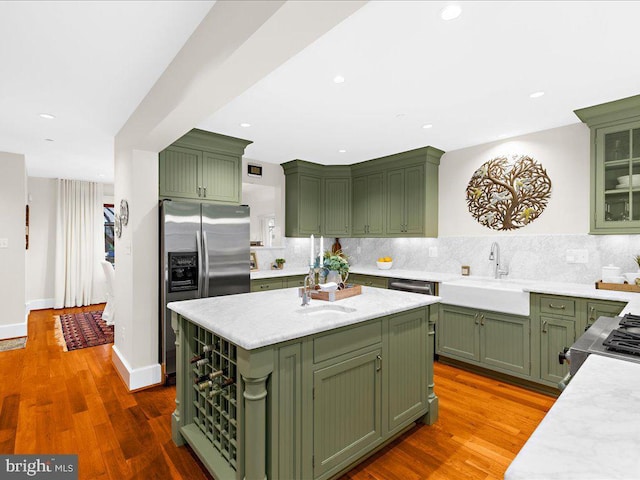 kitchen with sink, stainless steel refrigerator with ice dispenser, and green cabinets