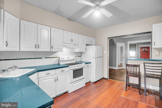 kitchen featuring white appliances, white cabinets, and sink