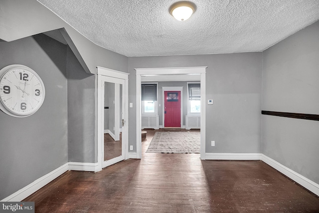 interior space with a textured ceiling and dark hardwood / wood-style floors