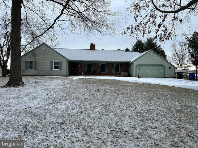 single story home with a garage, a chimney, and brick siding