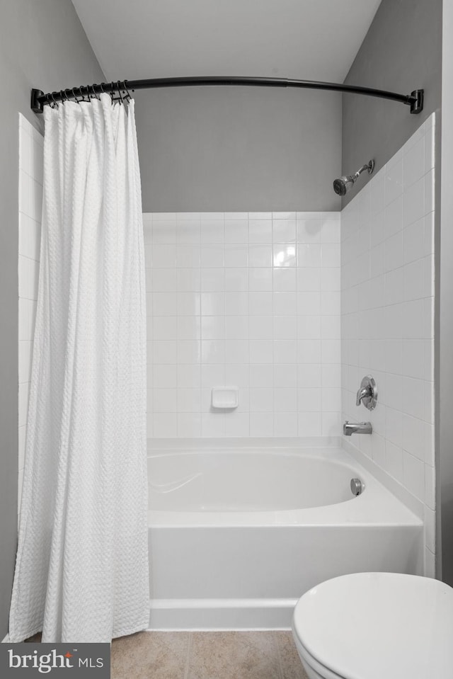 bathroom featuring tile patterned flooring, shower / bath combination with curtain, and toilet