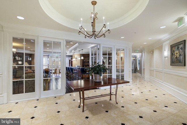 dining area featuring french doors, crown molding, an inviting chandelier, and a tray ceiling