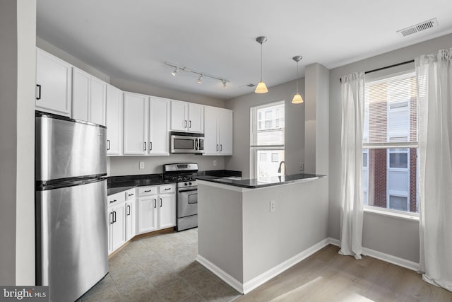 kitchen featuring white cabinetry, sink, hanging light fixtures, kitchen peninsula, and stainless steel appliances