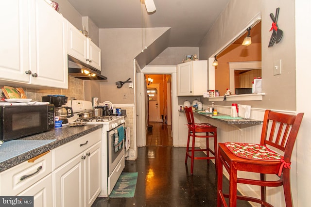 kitchen featuring a breakfast bar, white cabinetry, and white range with gas cooktop