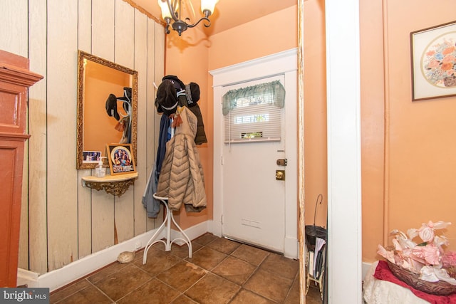 entryway with wood walls and a notable chandelier