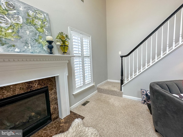 carpeted foyer with a fireplace