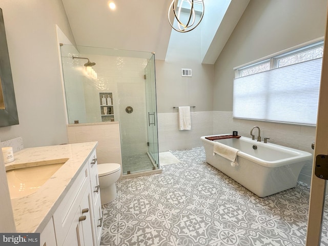 full bathroom with toilet, shower with separate bathtub, vaulted ceiling, tile walls, and tile patterned flooring