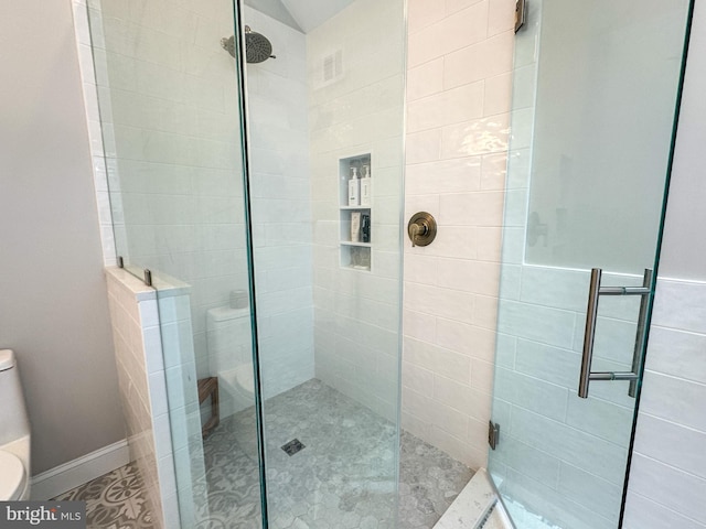 bathroom with toilet and a shower with door