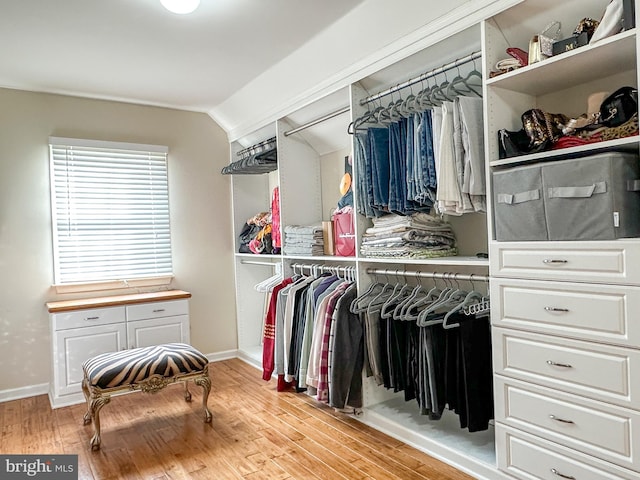 walk in closet with vaulted ceiling and light wood-type flooring