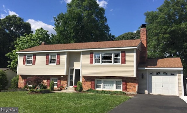 split foyer home featuring a garage and a front lawn