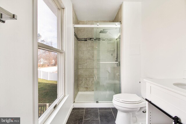 bathroom with vanity, tile patterned flooring, a shower with shower door, and toilet