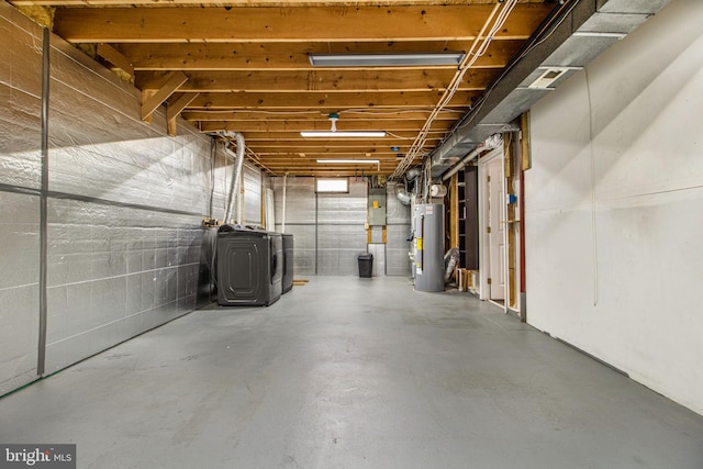 basement with water heater, electric panel, and independent washer and dryer