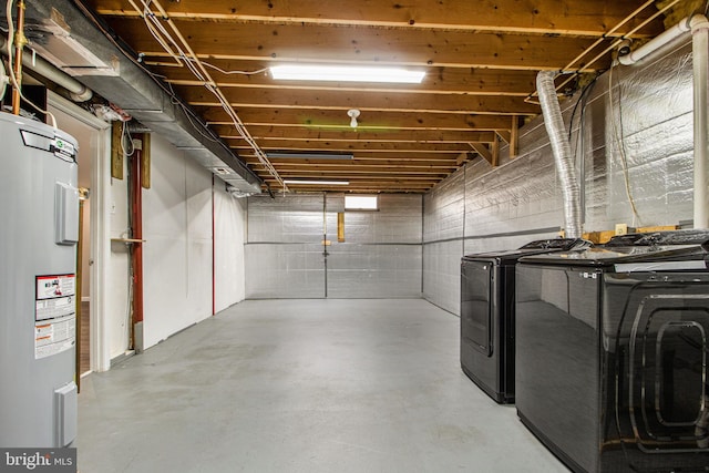 basement with electric water heater and separate washer and dryer