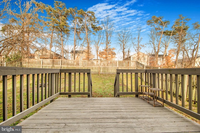 wooden deck featuring a lawn