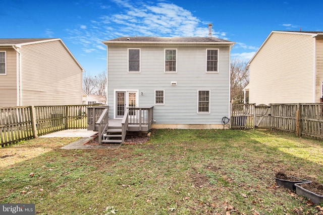 rear view of house featuring a lawn and a deck